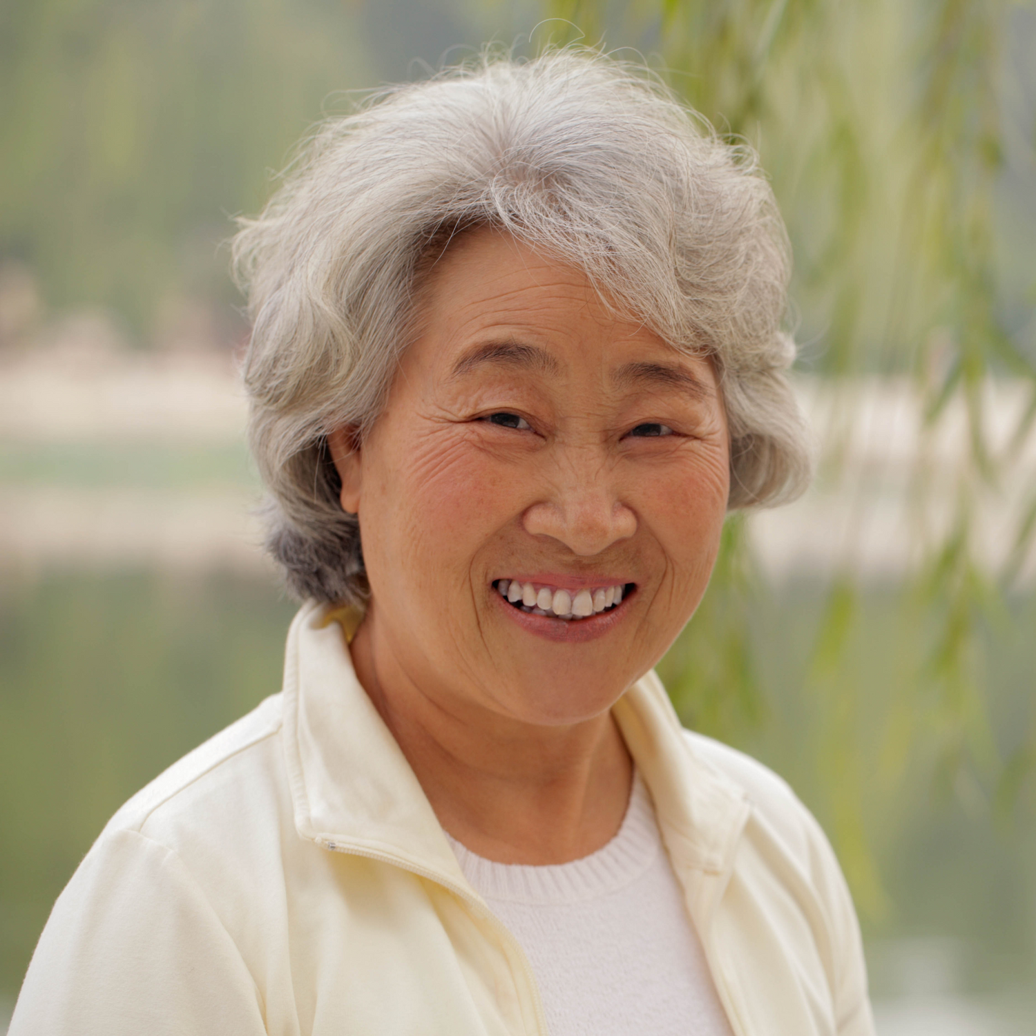 Smiling elderly female knee replacement patient with gray hair outdoors