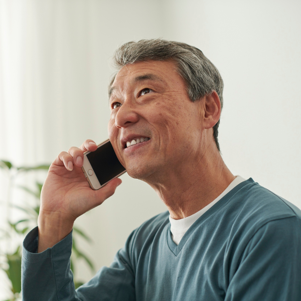 Male hip replacement patient talking on a smartphone with a blurred background